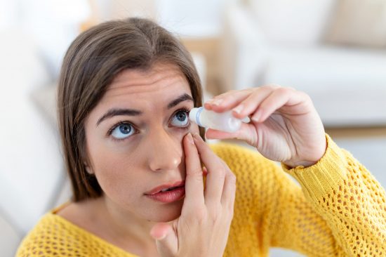 Woman using eye drop, woman dropping eye lubricant to treat dry eye or allergy